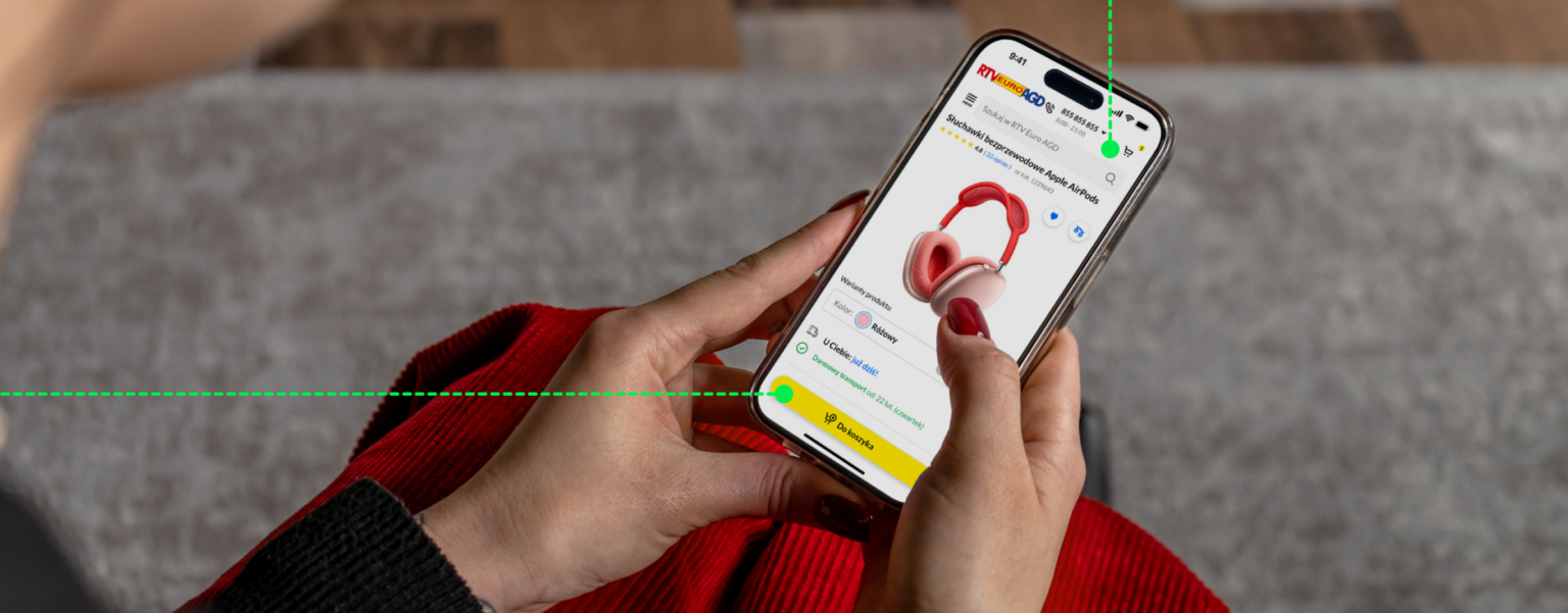 Osoba trzymająca smartfon z otwartą aplikacją mobilną sklepu EURO RTV AGD, prezentującą słuchawki bezprzewodowe. Grafika ilustruje zalety aplikacji mobilnych, takich jak łatwość obsługi, spójne doświadczenie użytkownika oraz dostępność funkcji na różnych platformach. Projekt wdrożony przez SYZYGY Warsaw, wykorzystujący rozwiązania aplikacji natywnych i ich funkcjonalność w systemie operacyjnym iOS.